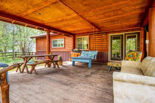 a porch of a log cabin with a table and chairs at Syringa House in McCall