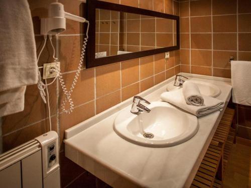 a bathroom with a sink and a mirror at Apartamentos Boabdil in Sierra Nevada