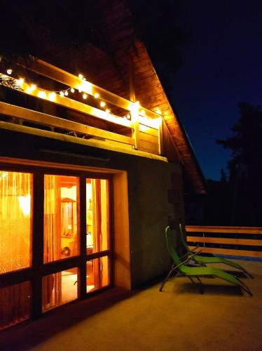 a green chair sitting in front of a building with lights at Lázeňská chata Hvězdička in Litoměřice