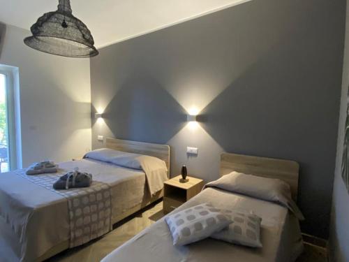 sypialnia z 2 łóżkami i lampką w obiekcie The Dream B&B w mieście Belvedere Marittimo