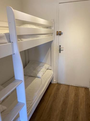 Cette petite chambre dispose de lits superposés et d'une porte. dans l'établissement Agréable studio cabine à 5 min à pied de la plage, au Grau-du-Roi