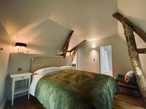 een slaapkamer met een groot bed op zolder bij Gîte Domanial en Périgord Noir in Cénac-et-Saint-Julien