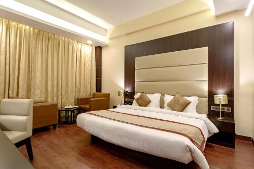 a hotel room with a large bed and a chair at Vivanta Jamshedpur, Golmuri in Jamshedpur