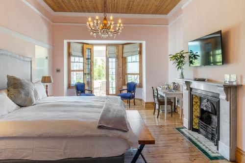 a bedroom with a bed and a fireplace and a chandelier at Villa Bianca B & B in Cape Town