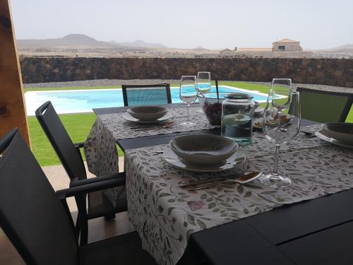 a table with a table cloth with wine glasses on it at Villa Los Volcanes in Lajares