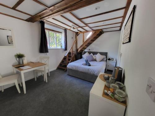 - une chambre avec un lit, un bureau et un escalier dans l'établissement The Dolphin, à Winchester