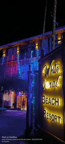 a sign in front of a beach resort at night at white coral beach resort in Havelock Island