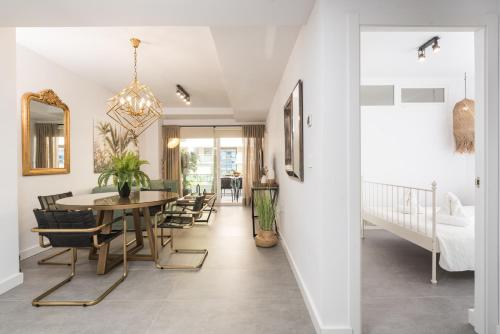 a dining room and living room with a table and chairs at Roy Boston Marbella by Florentia Homes in Marbella