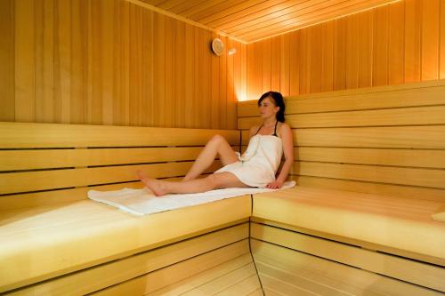 a woman is sitting in a sauna at Bildungszentrum Erkner in Erkner