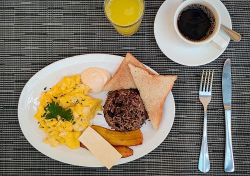 a plate of breakfast food with a cup of coffee at Hotel Giada in Sámara