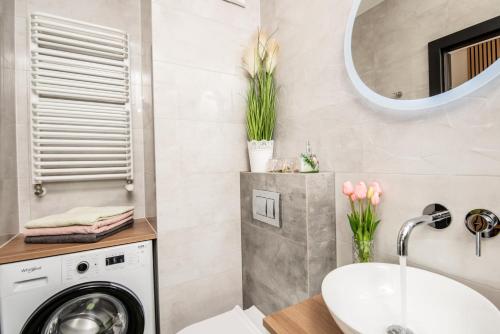 a bathroom with a washing machine and a sink at Apartament w Gąskach - Anielskie Wakacje in Gąski