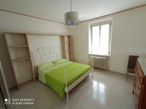 a bedroom with a bed with a green blanket at Interstellar in Aielli