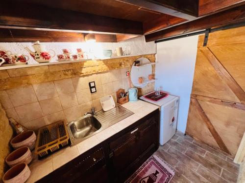 a small kitchen with a sink and a stove at Lindia Athena Traditional House in Karpathos