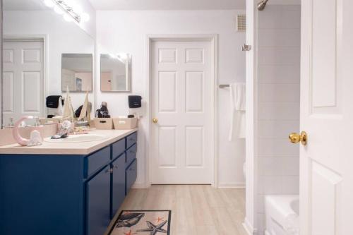 a bathroom with blue cabinets and a sink and a mirror at o STUNNING CONDO MINUTES FROM GORGEOUS BEACHES o in Clearwater
