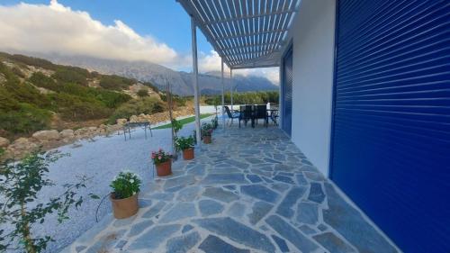 a patio with potted plants and a view of a mountain at Villa Edna Crete in Agios Nikolaos