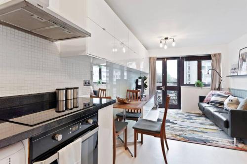 a kitchen and living room with a couch and a table at Modern 2 Bedroom Apartment in Hoxton in London