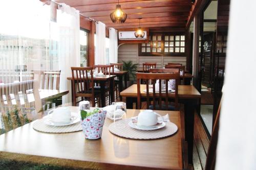 a restaurant with wooden tables and chairs and a table with hats at Cabanas Charme da Serra in Cambara do Sul