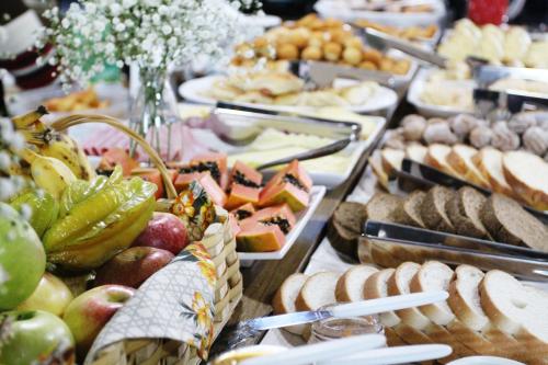 un buffet di diversi tipi di cibo su un tavolo di Cabanas Charme da Serra a Cambará