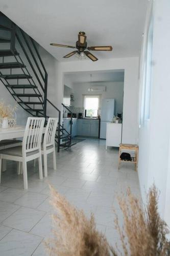 a living room with a ceiling fan and a table and chairs at Meraki Homestay Kanali in Kanali