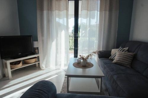 a living room with a couch and a tv and a table at Meraki Homestay Kanali in Kanali