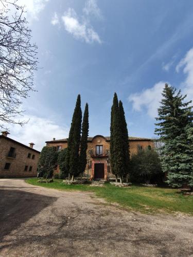 a house with trees in front of a driveway at Casa Palaciega El Cuartel in Medinaceli