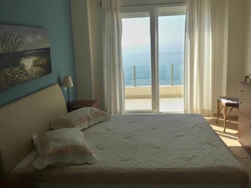 sypialnia z łóżkiem i widokiem na ocean w obiekcie KomiVillas w mieście Lilikás