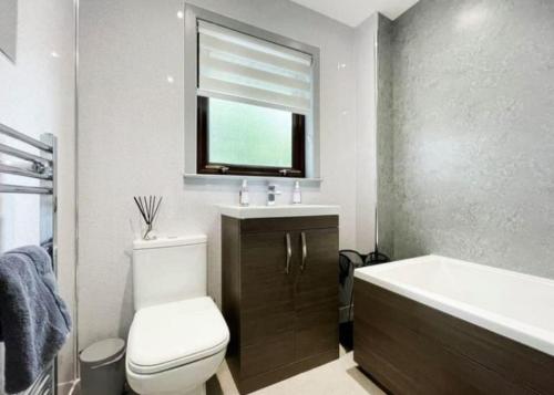 a bathroom with a toilet and a sink and a tub at BAYVIEW in Stornoway