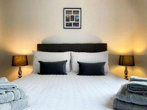 a bedroom with a large white bed with two lamps at BAYVIEW in Stornoway