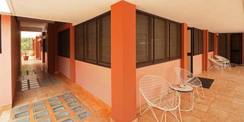 a room with chairs and tables in a building at Auromode Apartments Auroville in Auroville