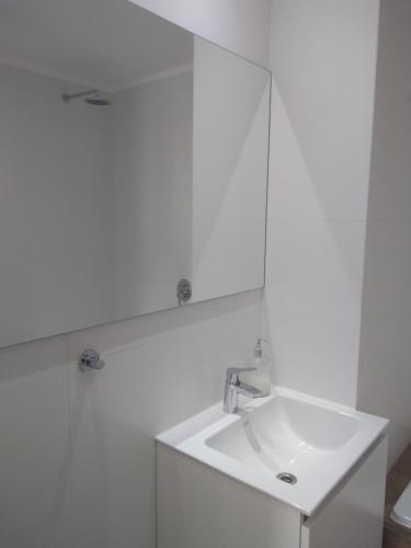 ein weißes Badezimmer mit einem Waschbecken und einem Spiegel in der Unterkunft 304 San Lorenzo in Mar del Plata