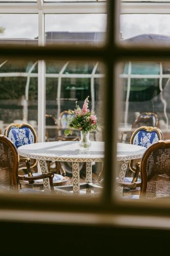 a table with a vase of flowers on it at Marine Troon in Troon