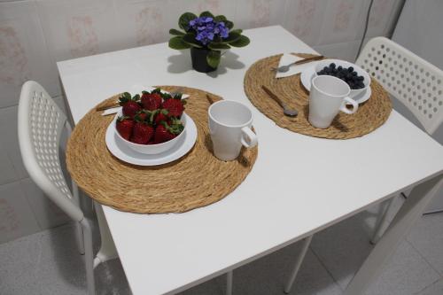 two plates of food on a white table with strawberries at Sea House Tajao in La Mareta