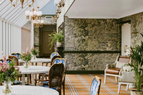 a dining room with tables and chairs and a wall mural at Marine Troon in Troon