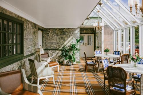 a conservatory with chairs and tables in a room at Marine Troon in Troon