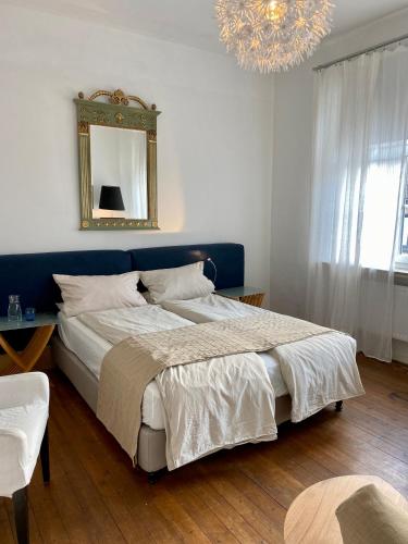 a bedroom with a bed with a mirror and a chandelier at Kläve12 Guesthouse in Oldenburg