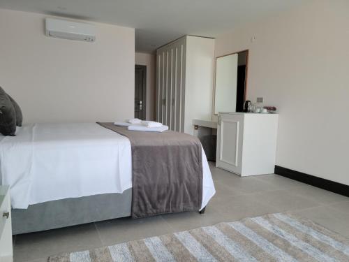 a bedroom with a white bed and a rug at The Mediteran Hotel in Kalkan