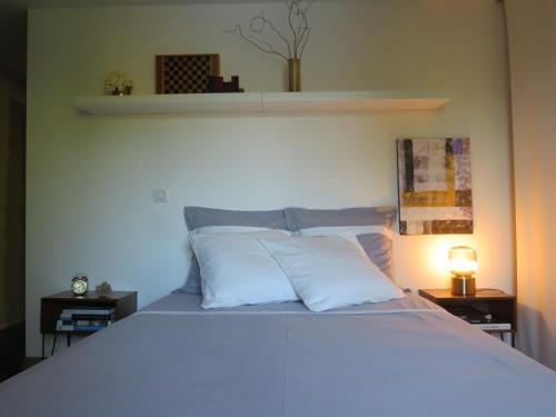 a bedroom with a large bed with white pillows at Au moulin de Pascaline 