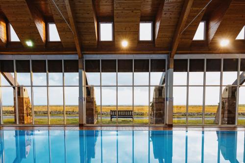 a swimming pool with a view of the field through windows at Marine Troon in Troon