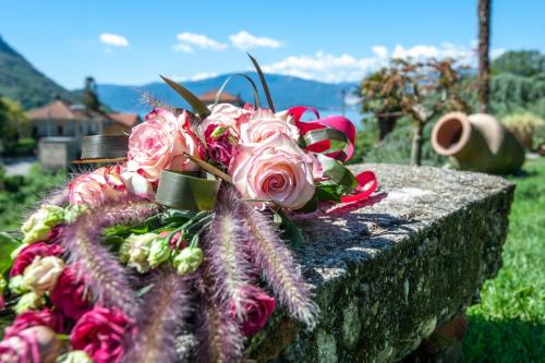 a bouquet of flowers sitting on a stone wall at il Motto di Tommy in Castelveccana