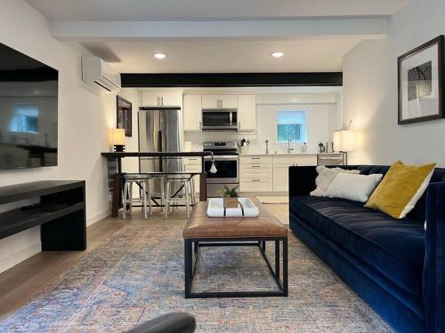 a living room with a blue couch and a kitchen at Modern, new & industrial in Georgetown in Seattle