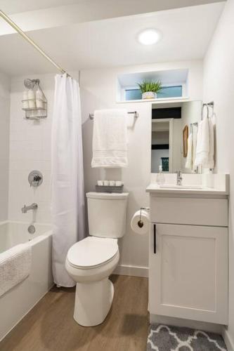 a white bathroom with a toilet and a sink at Artistic Georgetown Retreat in Seattle in Seattle