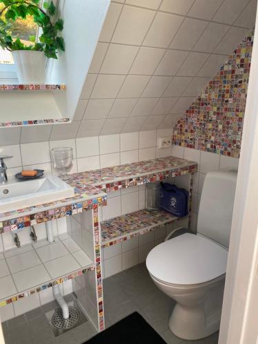 uma casa de banho com um WC e um lavatório em Fin lägenhet i hjärtat av Mölle em Mölle