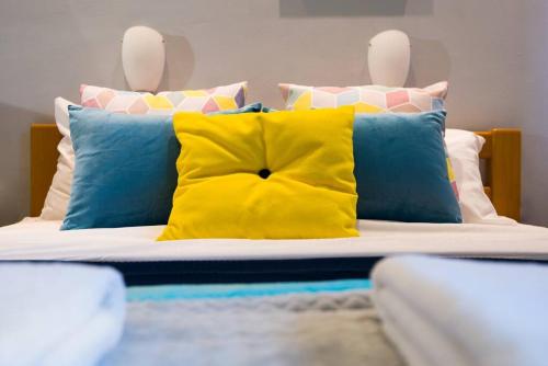a bed with blue and yellow pillows on it at Eliyahu Salman #2 in Jerusalem