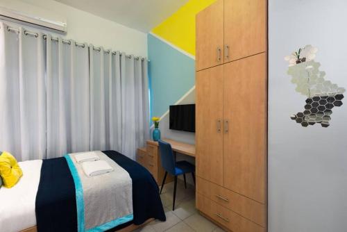 a bedroom with a bed and a desk with a television at Eliyahu Salman #2 in Jerusalem