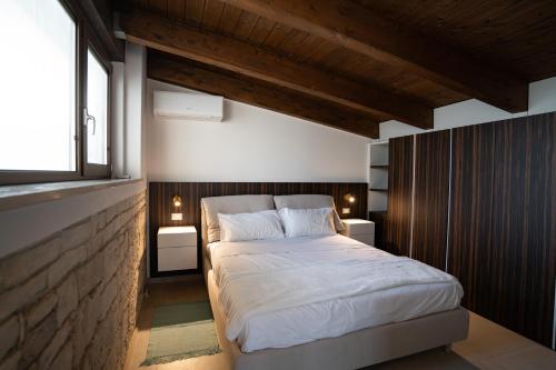 a bedroom with a large bed and a brick wall at Mansarda Monache (M&M) in Bitetto