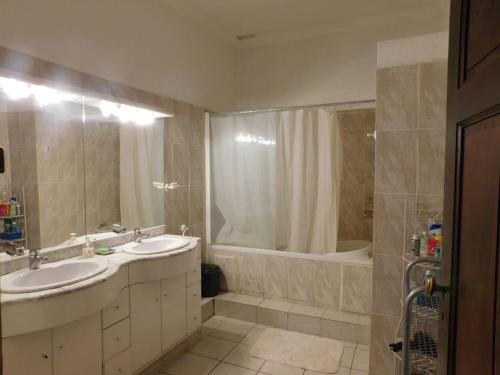 a bathroom with two sinks and a shower and a tub at Passerelle Opéra Perpignan in Perpignan