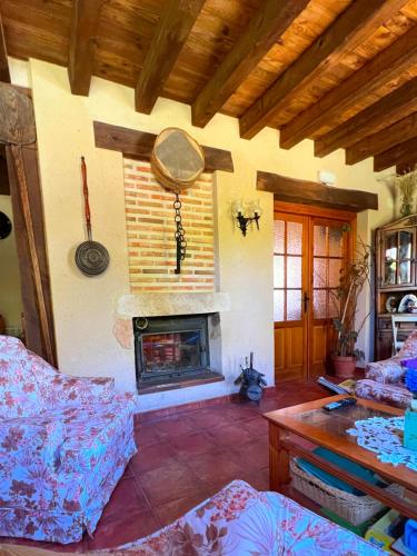 a living room with a fireplace and a couch at HOTEL RURAL LA HUERTA in Montejo de la Vega de la Serrezuela