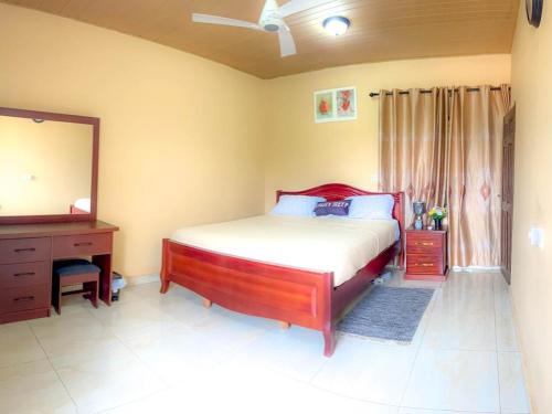 a bedroom with a bed and a dresser and a mirror at majestic cottage in Ayaso