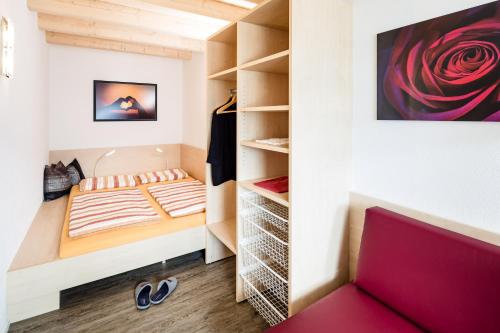 een kleine slaapkamer met een bed en een kast bij Haus Sauvignon in Cortaccia