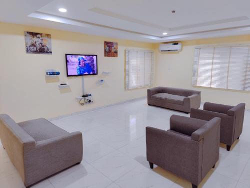 uma sala de espera com duas cadeiras e uma televisão de ecrã plano em Highly Secured 24 Hours Electricity Apartment em Garki